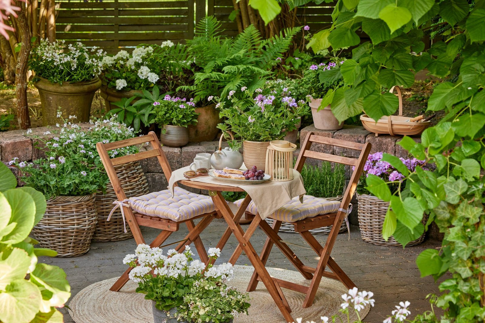Cap sur la Déco - Petit coin de paradis : terrasse chaleureuse avec table, chaises et plantes fleuries