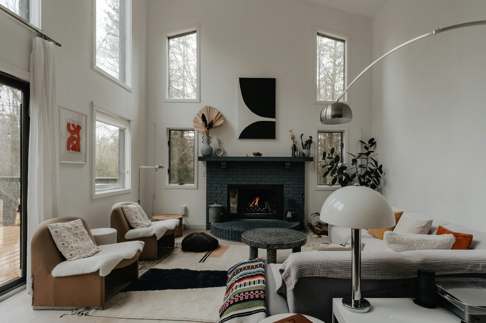Cap sur la Déco - Salon chaleureux décoré dans un style naturel avec cheminée, canapé confortable, textiles doux et plantes vertes